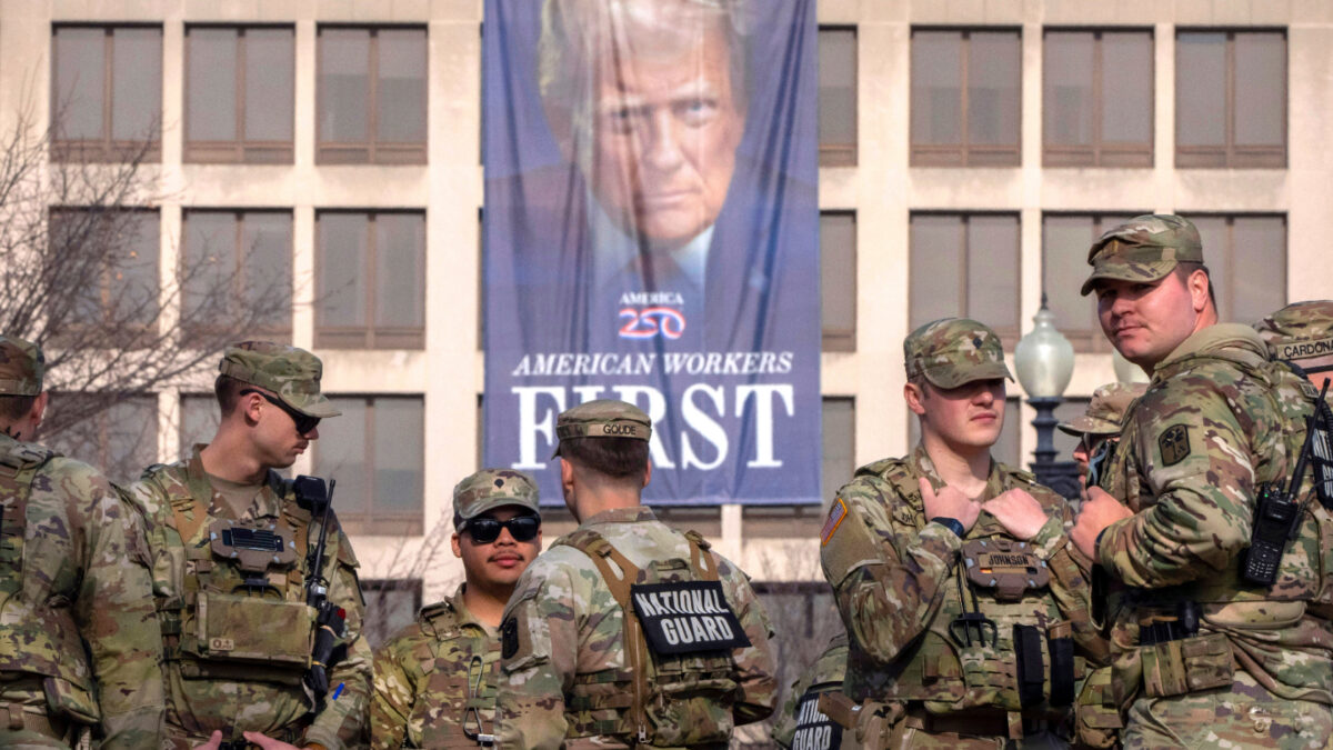 National Guard members gather near a large portrait of President Donald Trump on the Labor Department headquarters before the body of Metropolitan Police Department officer Terry Bennett is driven past the Capitol, Jan. 8, 2026, in Washington.